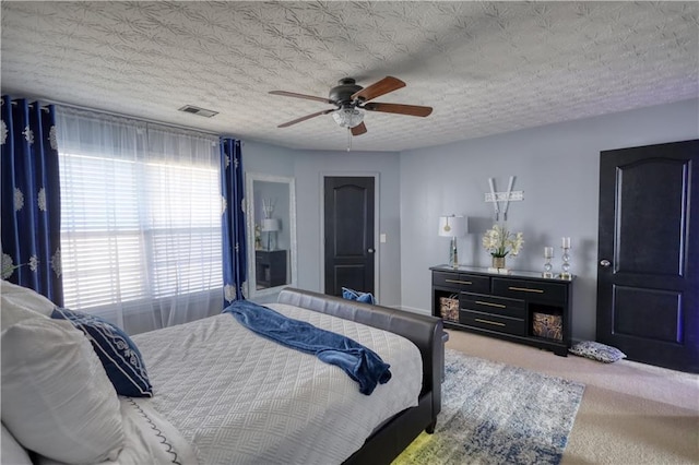 bedroom with carpet flooring, a textured ceiling, and ceiling fan