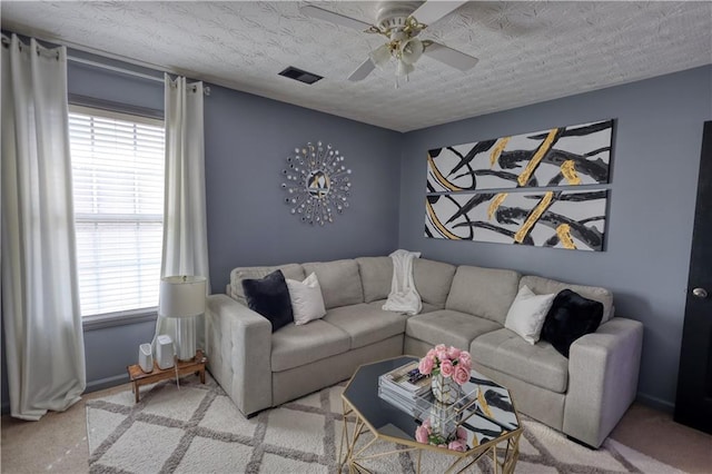 living room featuring ceiling fan and a textured ceiling