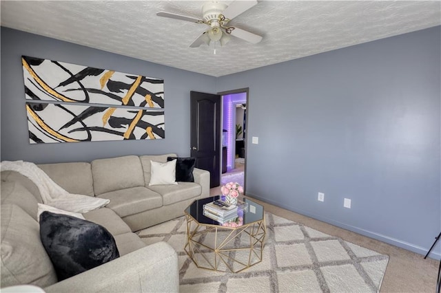 living room with ceiling fan, light carpet, and a textured ceiling