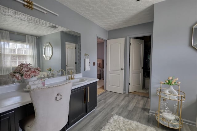 bathroom with vanity, hardwood / wood-style flooring, and a textured ceiling