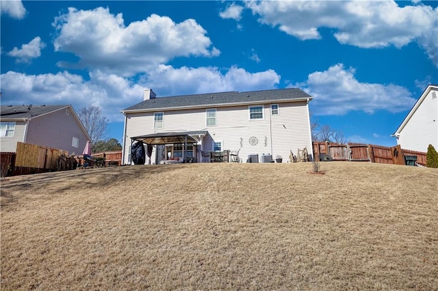 rear view of house with a carport and a yard