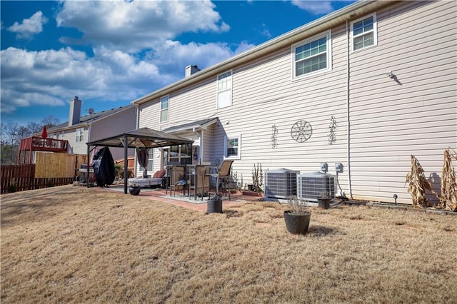 back of property with a gazebo, central AC, a patio area, and a lawn