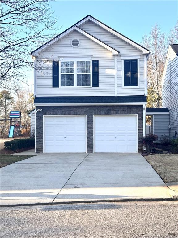 view of front of house with a garage and a playground