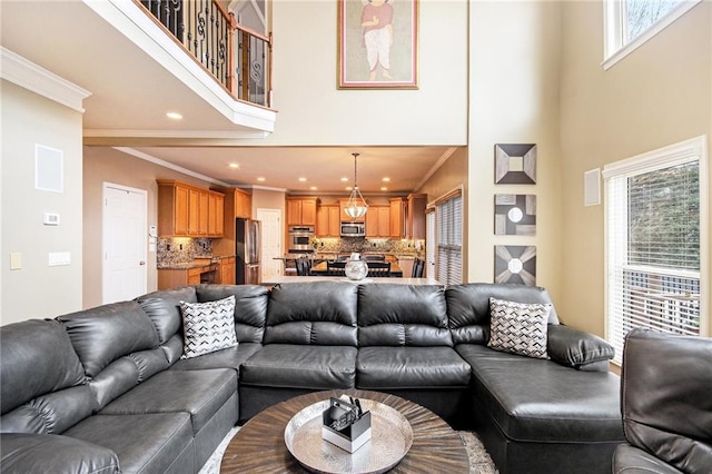 living room with ornamental molding, a towering ceiling, and recessed lighting