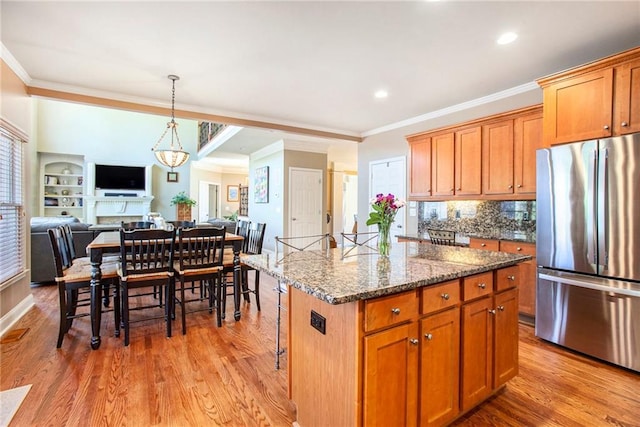 kitchen featuring light wood-style floors, open floor plan, a wealth of natural light, and freestanding refrigerator