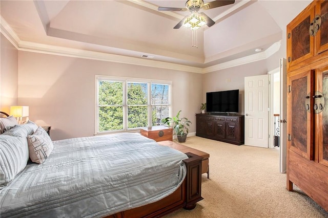 bedroom with crown molding, ceiling fan, a tray ceiling, and light colored carpet