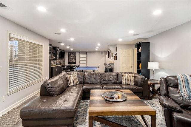 living room with baseboards, a barn door, visible vents, and recessed lighting