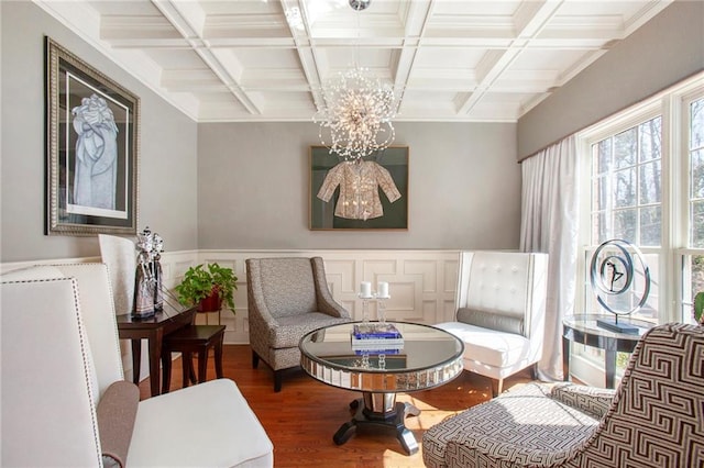 sitting room with beamed ceiling, coffered ceiling, wood finished floors, and an inviting chandelier