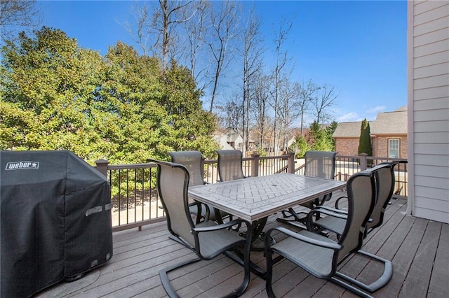 wooden terrace featuring outdoor dining area and grilling area