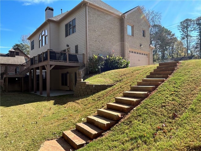 view of side of property with a lawn, a chimney, and a patio