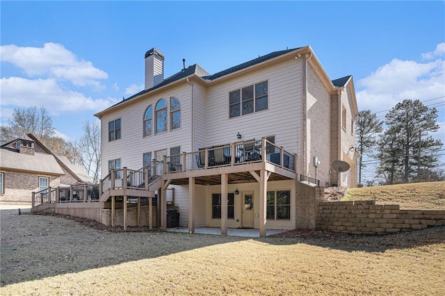 back of house with a deck, a chimney, and a patio area