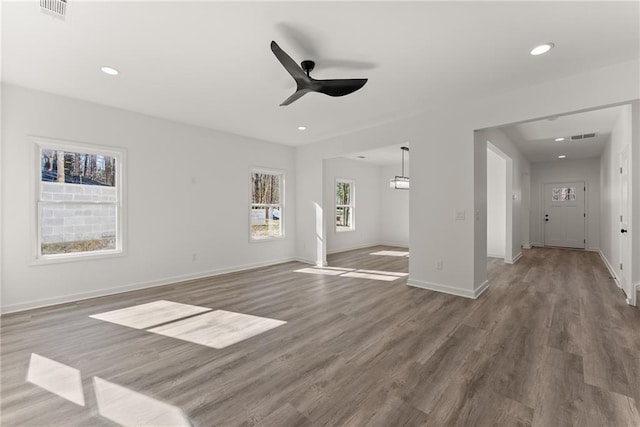 unfurnished living room featuring ceiling fan and dark hardwood / wood-style flooring