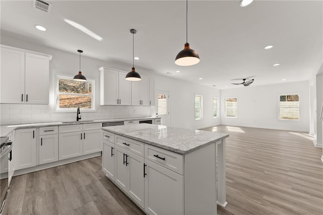 kitchen with ceiling fan, sink, white cabinetry, and hanging light fixtures