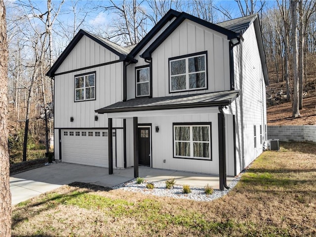 view of front of home with a garage, a front yard, central AC unit, and a porch