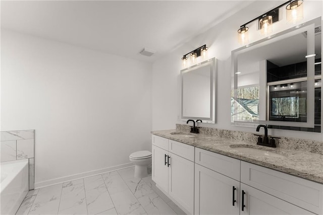 bathroom with toilet, a tub to relax in, and vanity