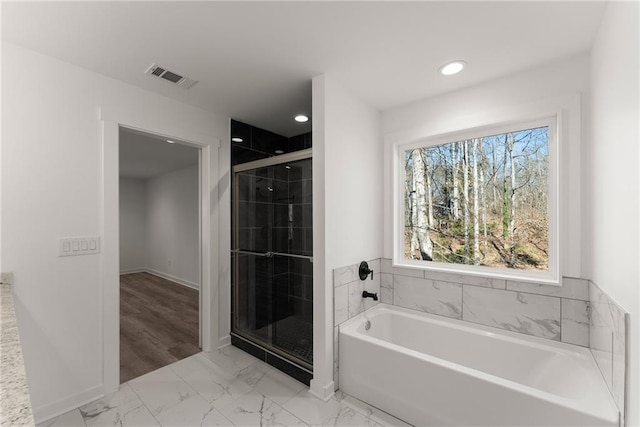 bathroom featuring independent shower and bath and a healthy amount of sunlight