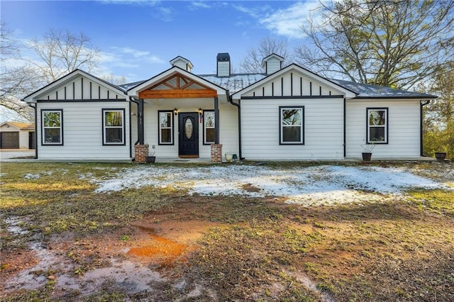 modern farmhouse style home with board and batten siding and a chimney