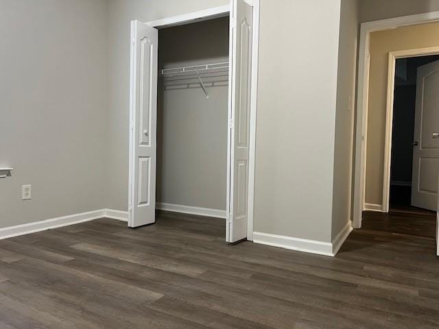 unfurnished bedroom featuring a closet and dark hardwood / wood-style flooring