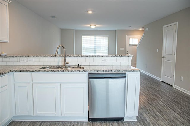 kitchen featuring dark stone counters, white cabinetry, dishwasher, and sink