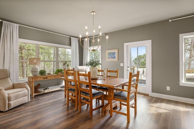 dining space featuring healthy amount of natural light, wood finished floors, and a chandelier