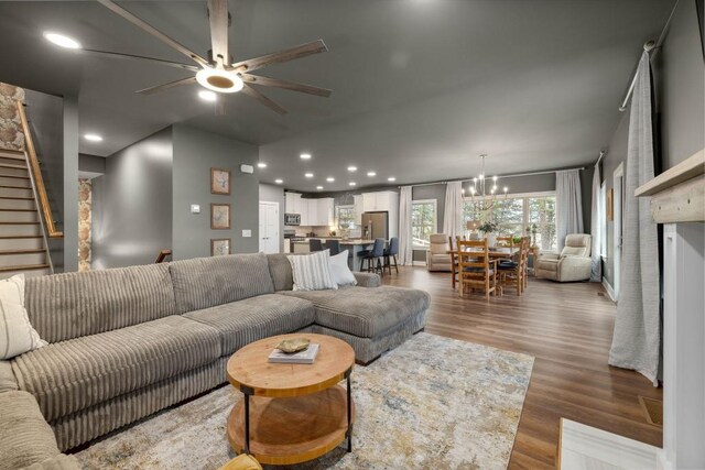 living area with ceiling fan, wood finished floors, stairway, a chandelier, and recessed lighting