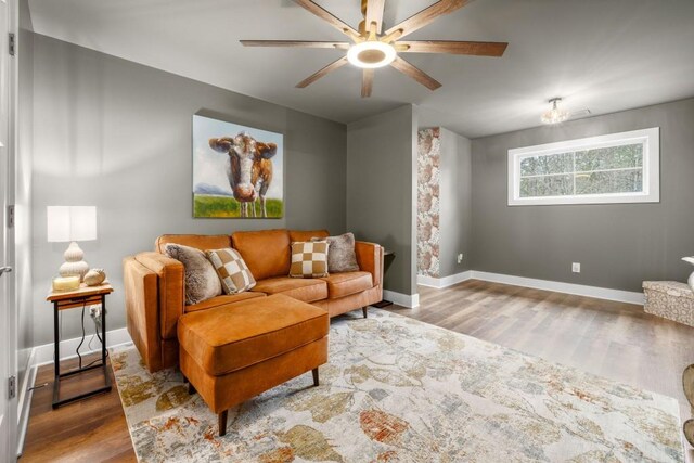 living room featuring wood finished floors, baseboards, and ceiling fan