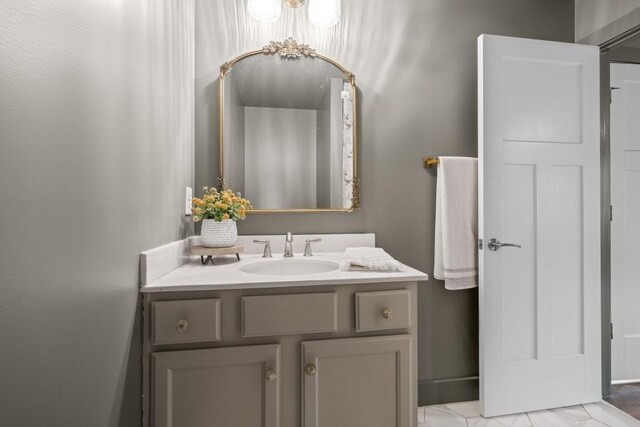 bathroom featuring vanity and marble look tiles