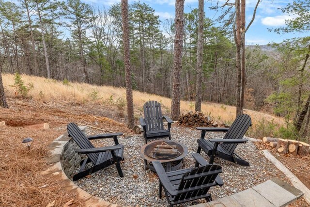 view of patio / terrace featuring a fire pit and a view of trees