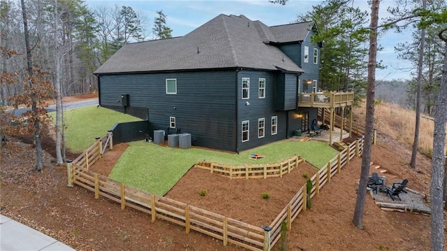 back of property featuring a wooden deck, roof with shingles, and central AC unit