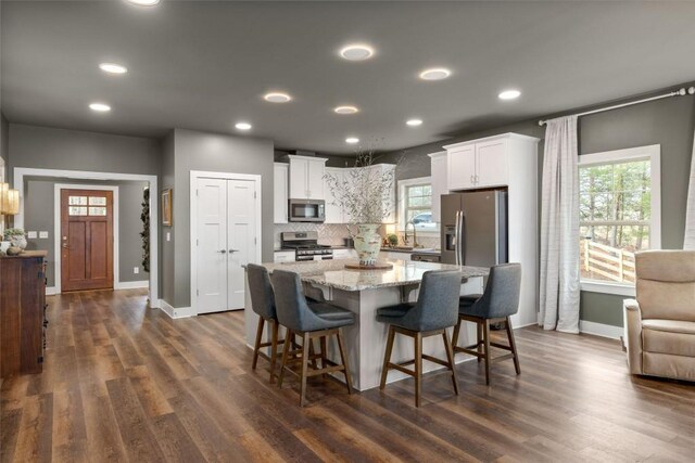 kitchen with appliances with stainless steel finishes, white cabinets, recessed lighting, and healthy amount of natural light
