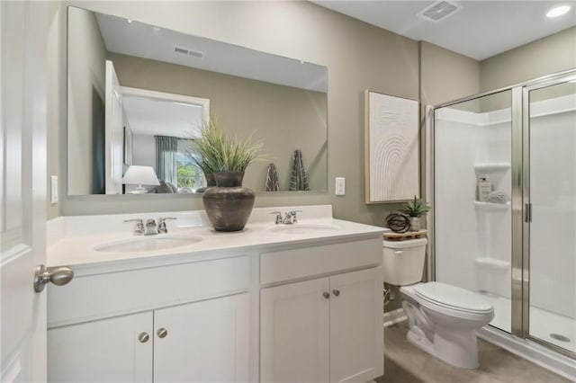 bathroom with a shower with door, vanity, and toilet