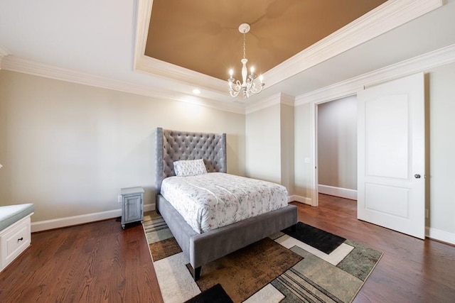 bedroom featuring a chandelier, dark hardwood / wood-style floors, crown molding, and a tray ceiling