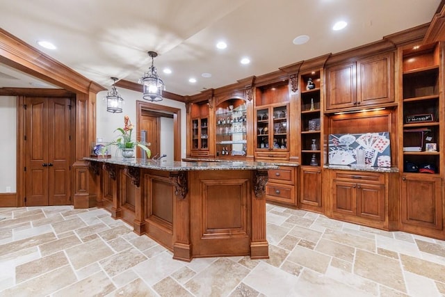 bar featuring light stone countertops, decorative light fixtures, and crown molding