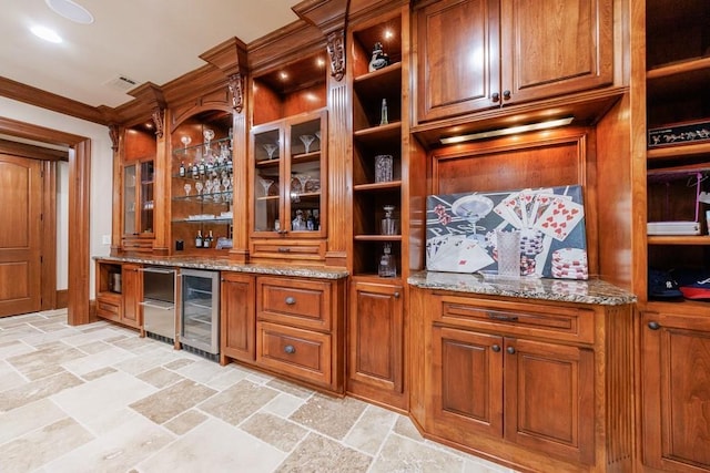 bar with light stone countertops, ornamental molding, and wine cooler