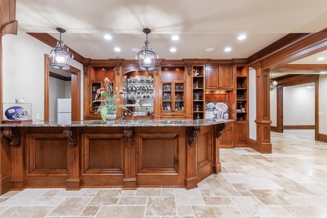 bar with decorative light fixtures, white fridge, dark stone countertops, and decorative columns