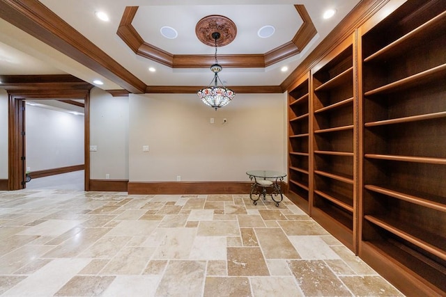 spare room featuring a raised ceiling and crown molding