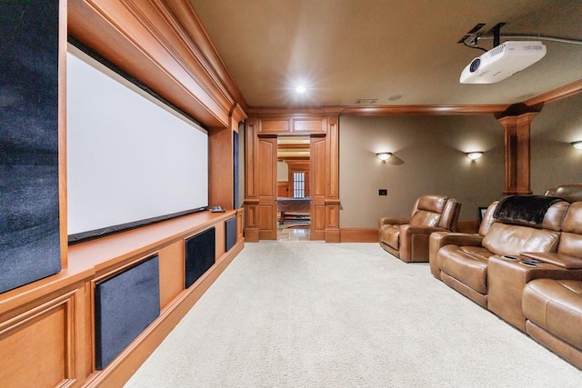 carpeted home theater featuring ornate columns and crown molding