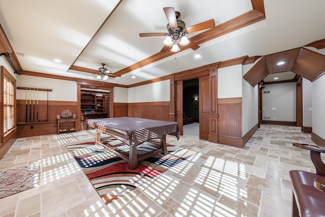 rec room with ceiling fan, crown molding, and a tray ceiling