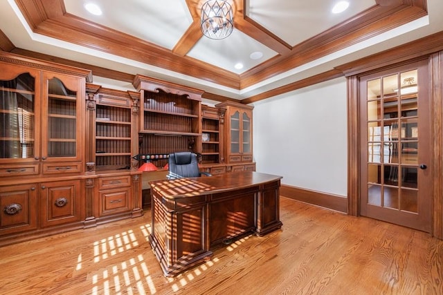 office area with a raised ceiling, crown molding, and light wood-type flooring