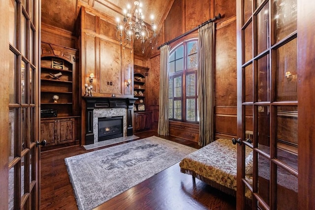 home office with a wealth of natural light, wooden walls, high vaulted ceiling, and dark wood-type flooring