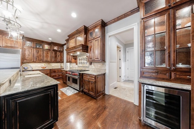 kitchen with sink, hanging light fixtures, beverage cooler, dark hardwood / wood-style flooring, and high end appliances