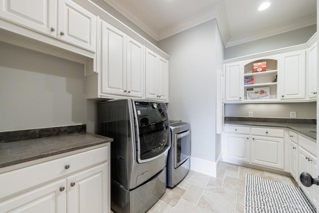 washroom featuring cabinets, crown molding, and washing machine and clothes dryer