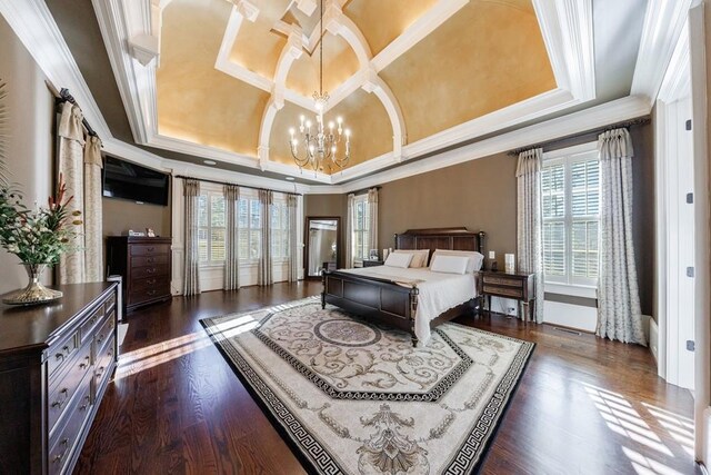 bedroom with dark hardwood / wood-style floors, a barn door, crown molding, and multiple windows