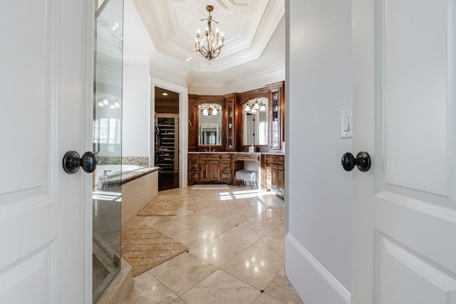 bathroom with a tub to relax in, vanity, a tray ceiling, crown molding, and a notable chandelier