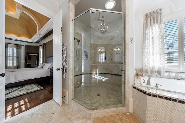 bathroom featuring separate shower and tub, wood-type flooring, ornamental molding, and an inviting chandelier