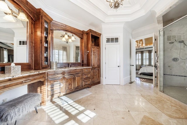 bathroom featuring a notable chandelier, a shower with door, crown molding, and vanity