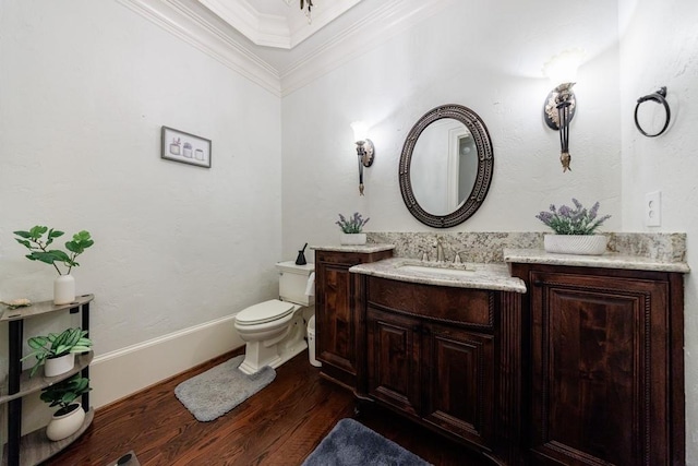 bathroom featuring toilet, vanity, wood-type flooring, and ornamental molding