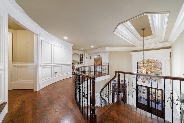 hallway featuring dark wood-type flooring, a notable chandelier, and ornamental molding