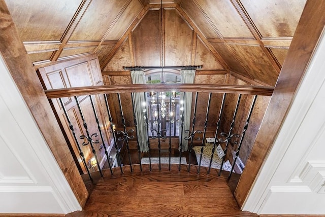 staircase with wood-type flooring, wood ceiling, lofted ceiling, and wood walls