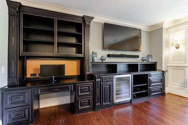 bar with dark hardwood / wood-style flooring, built in desk, crown molding, and beverage cooler